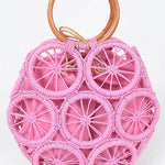 Bright pink woven circle tote bag with wooden ring handles and raffia sunburst design—boho summer handbag.