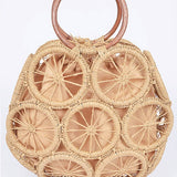 Natural raffia woven circle handbag with wooden ring handles and sunburst pattern—neutral beach tote