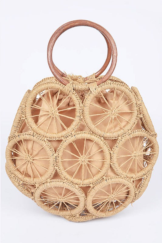 Natural raffia woven circle handbag with wooden ring handles and sunburst pattern—neutral beach tote