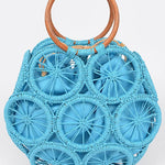 Ocean-blue raffia sunburst circle tote with wooden round handles—statement woven beach bag.