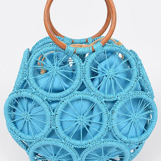 Ocean-blue raffia sunburst circle tote with wooden round handles—statement woven beach bag.
