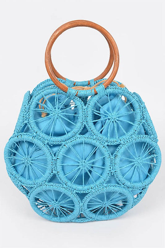 Ocean-blue raffia sunburst circle tote with wooden round handles—statement woven beach bag.