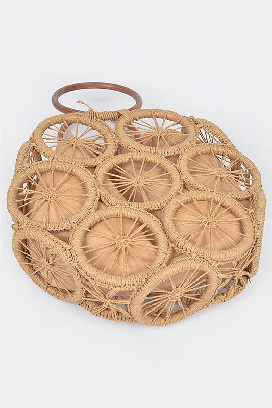 Natural raffia woven circle handbag with wooden ring handles and sunburst pattern—neutral beach tote