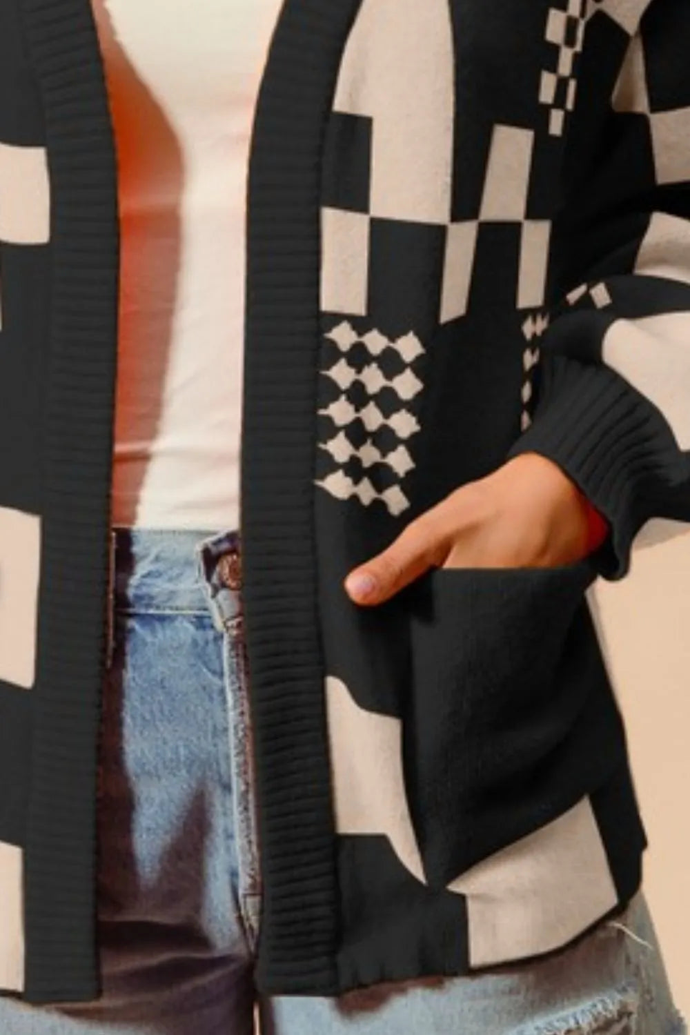 Women's black and cream checkerboard patchwork knit cardigan with open front and front pockets – cozy geometric print sweater for layering.