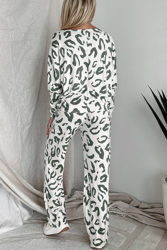 Back view of woman wearing sage green and white leopard print two-piece lounge set with long sleeves and wide-leg pants.