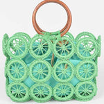 Mint green raffia circle-grid tote with wooden round handles and teal drawstring insert.