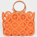 Vibrant orange woven circle-grid straw tote with wooden ring handles—boho summer purse.