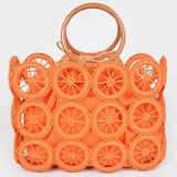 Vibrant orange woven circle-grid straw tote with wooden ring handles—boho summer purse.