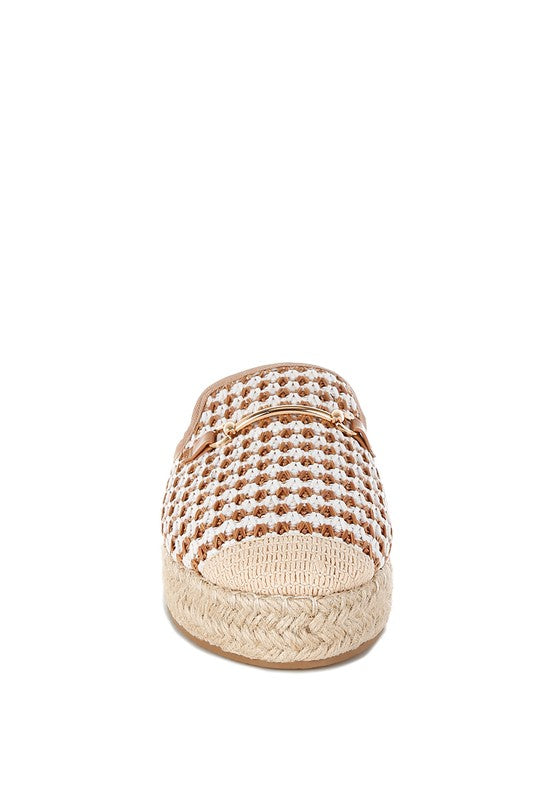 Women’s woven raffia mule espadrille with gold horse-bit hardware and jute platform, shown in black-ivory and tan-white color options.