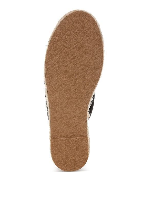 Women’s woven raffia mule espadrille with gold horse-bit hardware and jute platform, shown in black-ivory and tan-white color options.