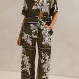 Olive green floral lounge set for women featuring short-sleeve button-down top and wide-leg pants with white botanical print – perfect for casual chic or resort wear.