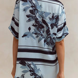 Light blue floral two-piece lounge set for women with short-sleeve button-down shirt and drawstring wide-leg pants, featuring navy botanical print – perfect for vacation, resort wear, or chic loungewear looks.