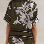 Olive green floral lounge set for women featuring short-sleeve button-down top and wide-leg pants with white botanical print – perfect for casual chic or resort wear.