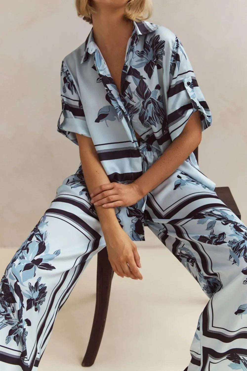 Light blue floral two-piece lounge set for women with short-sleeve button-down shirt and drawstring wide-leg pants, featuring navy botanical print – perfect for vacation, resort wear, or chic loungewear looks.