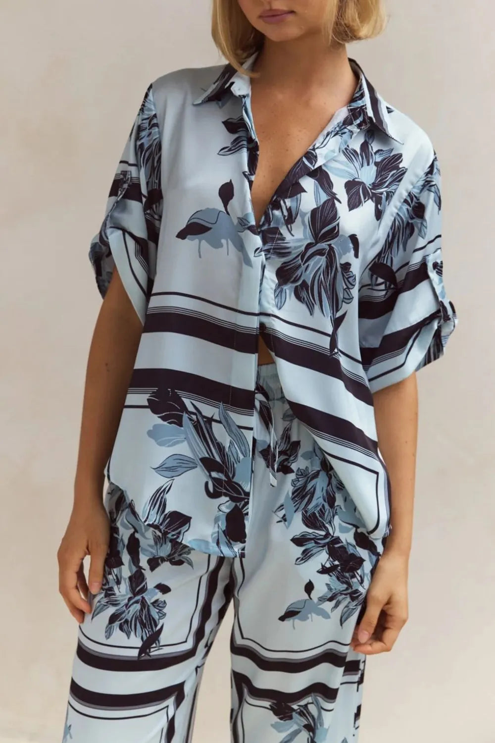 Light blue floral two-piece lounge set for women with short-sleeve button-down shirt and drawstring wide-leg pants, featuring navy botanical print – perfect for vacation, resort wear, or chic loungewear looks.