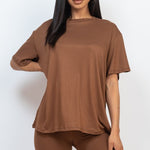 Women's oversized two-piece lounge set featuring a relaxed fit short-sleeve tee and high-waisted biker shorts, available in multiple vibrant colors. Perfect for casual wear, workouts, or athleisure style.