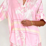 Women's blush pink tropical lily stripe two-piece outfit with loose button shirt and comfy drawstring shorts for resort wear.