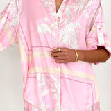 Women's blush pink tropical lily stripe two-piece outfit with loose button shirt and comfy drawstring shorts for resort wear.
