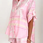 Women's blush pink tropical lily stripe two-piece outfit with loose button shirt and comfy drawstring shorts for resort wear.