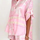 Women's blush pink tropical lily stripe two-piece outfit with loose button shirt and comfy drawstring shorts for resort wear.