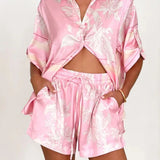 Women's blush pink tropical lily stripe two-piece outfit with loose button shirt and comfy drawstring shorts for resort wear.