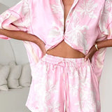 Women's blush pink tropical lily stripe two-piece outfit with loose button shirt and comfy drawstring shorts for resort wear.