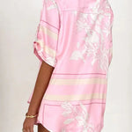 Women's blush pink tropical lily stripe two-piece outfit with loose button shirt and comfy drawstring shorts for resort wear.