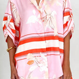 Women's blush pink tropical lily stripe two-piece outfit with loose button shirt and comfy drawstring shorts for resort wear.