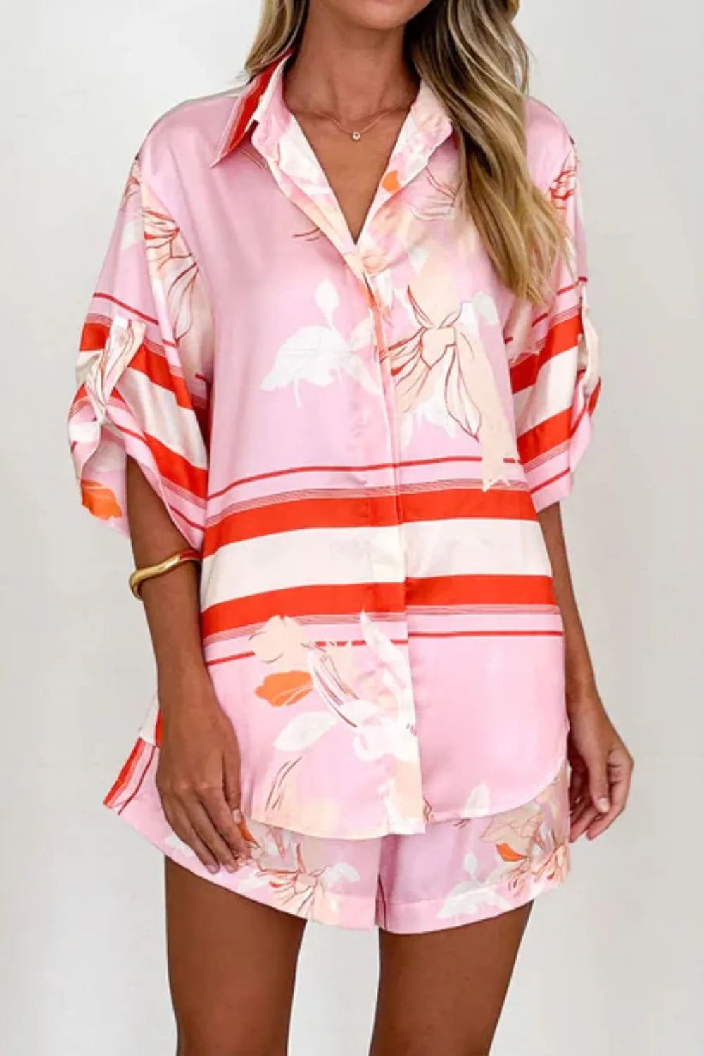 Women's blush pink tropical lily stripe two-piece outfit with loose button shirt and comfy drawstring shorts for resort wear.