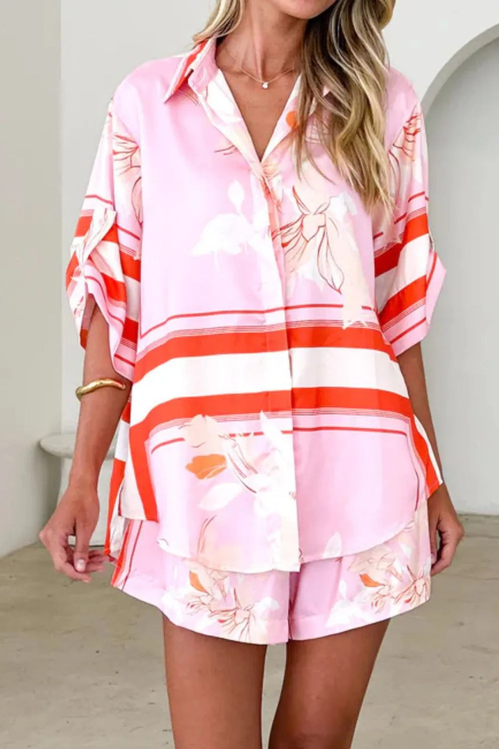 Women's blush pink tropical lily stripe two-piece outfit with loose button shirt and comfy drawstring shorts for resort wear.