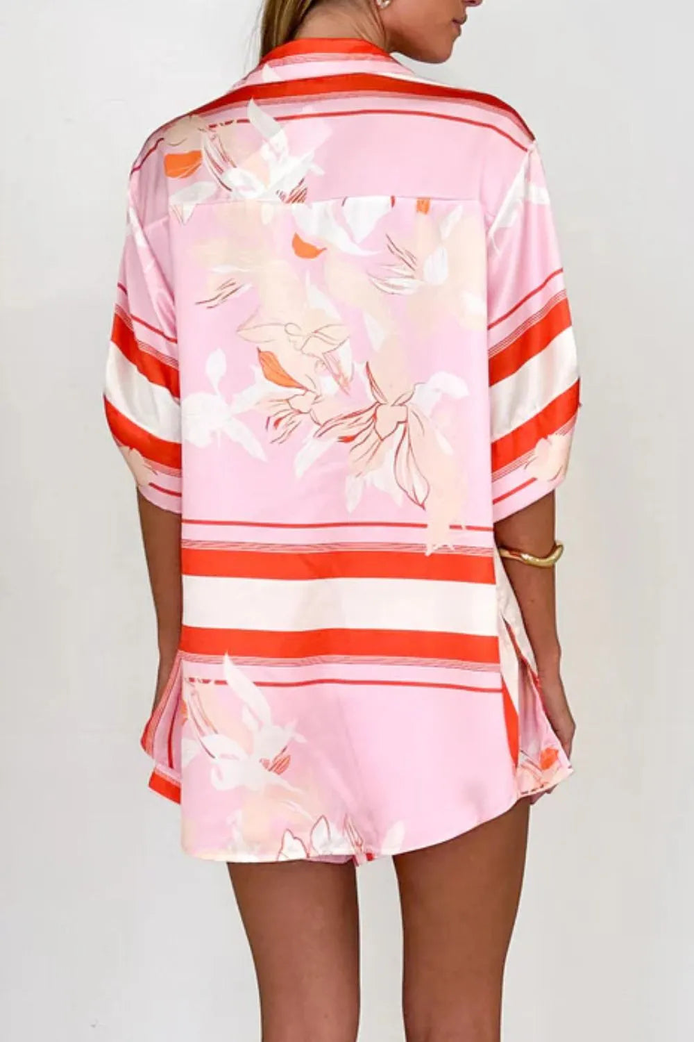 Women's blush pink tropical lily stripe two-piece outfit with loose button shirt and comfy drawstring shorts for resort wear.