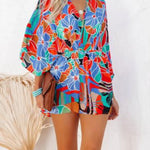 Women's multicolor tropical floral and geometric kimono-sleeve romper featuring surplice V-neck, cinched waist, and relaxed shorts—ideal for vacation wear.