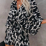 Women's black and taupe abstract animal-print kimono-sleeve romper with deep V-neck, cinched elastic waist, and flowy shorts.