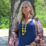 Double strand blue lapis lazuli bead necklace with natural gold and gray flecks, displayed on a light wooden surface.