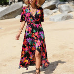 Women's tropical neon floral high-low wrap dress with flutter sleeves, V-neckline, and belted waist – lightweight chiffon vacation maxi.