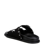 Women’s nubuck faux leather slide sandals with silver buckle straps, metal eyelet embellishments, and flat black soles in olive green and black color options.