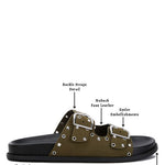 Women’s nubuck faux leather slide sandals with silver buckle straps, metal eyelet embellishments, and flat black soles in olive green and black color options.