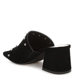 Black microsuede open-toe mule with silver cone studs and mid block heel, shown from multiple angles against white background.