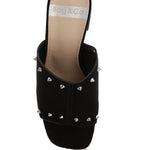 Black microsuede open-toe mule with silver cone studs and mid block heel, shown from multiple angles against white background.