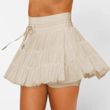 Women's sand beige ruffle tennis skort with high-waist fit, adjustable drawstring, and built-in stretch shorts for workouts.