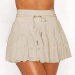 Women's sand beige ruffle tennis skort with high-waist fit, adjustable drawstring, and built-in stretch shorts for workouts.