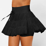 Women's black high-waist ruffle athletic skort with triple mesh tiers, drawstring waistband, and hidden shorts.