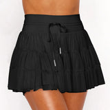 Women's black high-waist ruffle athletic skort with triple mesh tiers, drawstring waistband, and hidden shorts.