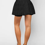 Women's black high-waist ruffle athletic skort with triple mesh tiers, drawstring waistband, and hidden shorts.