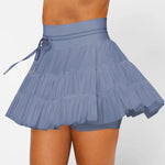 Women's slate blue ruffle workout skort with moisture-wicking fabric, high-rise drawstring waist, and built-in shorts.