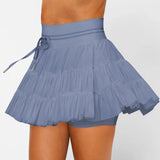 Women's slate blue ruffle workout skort with moisture-wicking fabric, high-rise drawstring waist, and built-in shorts.