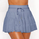 Women's slate blue ruffle workout skort with moisture-wicking fabric, high-rise drawstring waist, and built-in shorts.