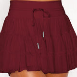 Women's wine red ruffle athletic skort with high-waist drawstring waistband and built-in shorts – moisture-wicking tennis skirt.
