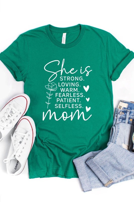 Mint Green graphic T-shirt reading ‘She is strong, loving, warm, fearless, patient, selfless—mom’ styled flat-lay with tan fedora, denim shorts, and greenery.