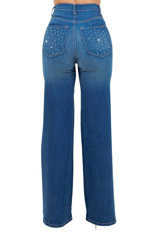 Woman modeling high-rise wide-leg blue “Starlight Rhinestone” jeans, denim sprinkled with sparkling crystal studs and star-dot back pockets.